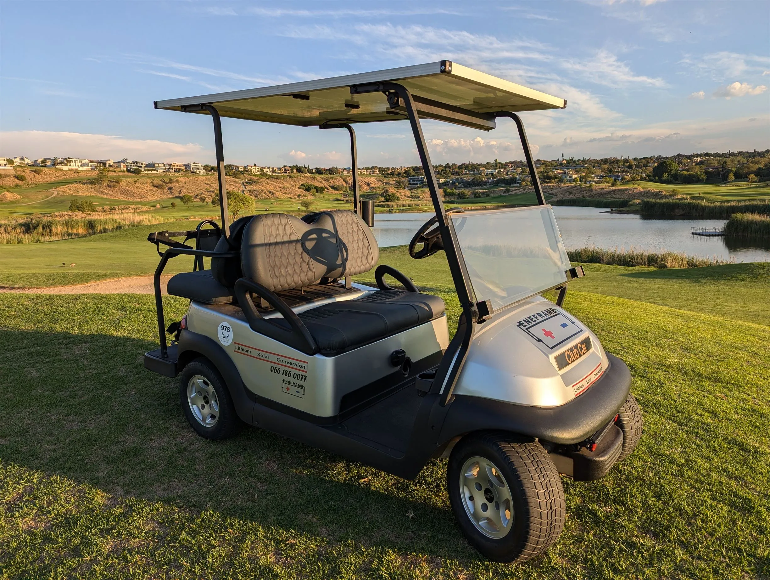 An EneFrame golf cart conversion with a solar roof beside a golf course